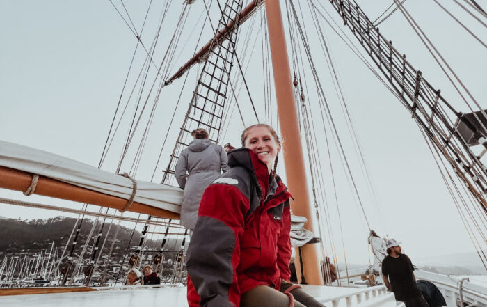 Volunteer Catherine Crow relaxing on the cabin top on Matthew Turner, after helping furl sails.